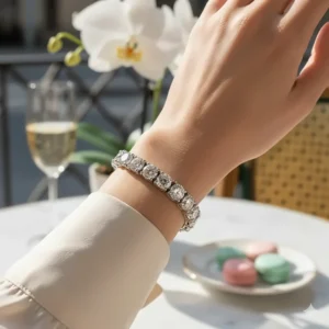 A woman's wrist adorned with a beautiful tennis-style silver diamond bracelet.