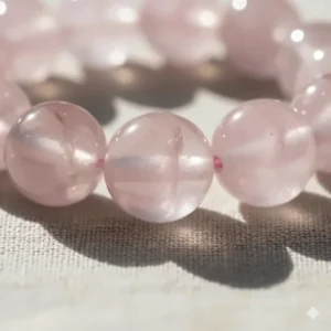 Close-up detail of high-quality rose quartz beads highlighting the internal clarity and subtle color variation of the healing crystal.