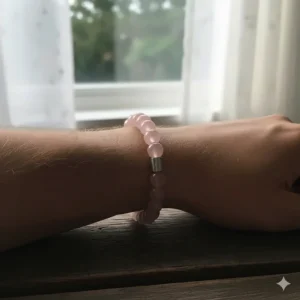 A shot showing the perfect, comfortable fit of the rose quartz bracelet on a man's wrist, highlighting its subtle pink hue.
