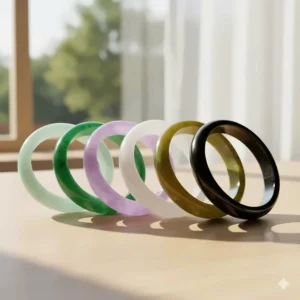 A collection of jade bangle bracelets showcasing the spectrum of colors available, including light green, lavender, and white jade.
