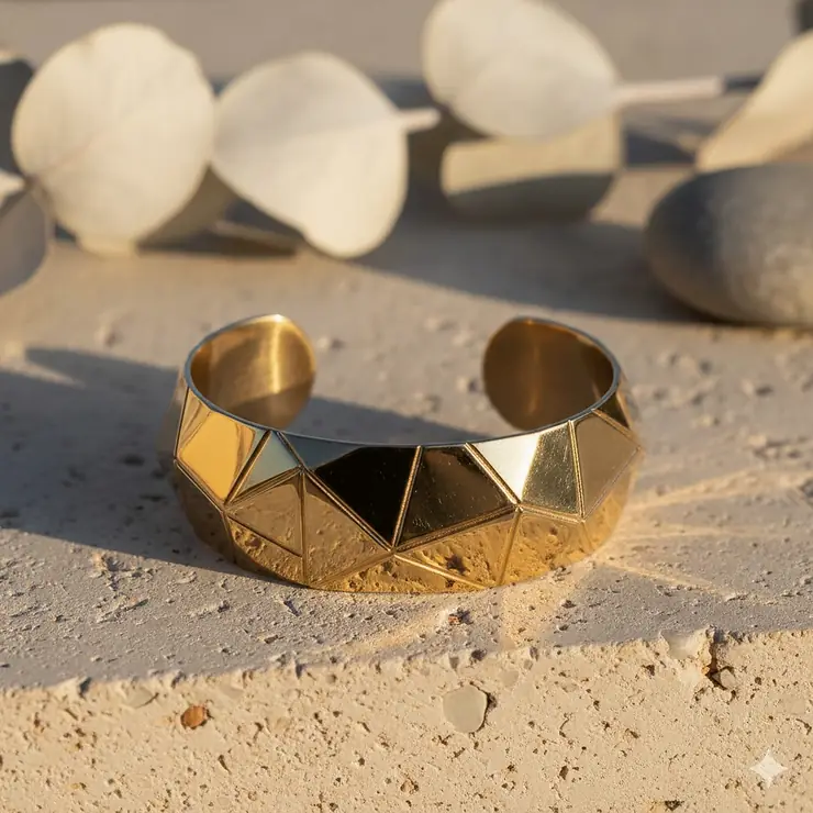 High-quality geometric gold cuff bracelet with a polished finish on a neutral background.