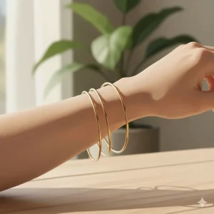 Photorealistic shot of thin gold bangles sliding freely down a forearm, demonstrating the loose fit and movement characteristic of bangles.