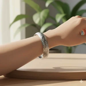 Close-up of a wide silver cuff bracelet sitting snugly and securely above the wrist bone, showing the fixed position of the jewelry.