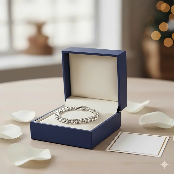 An elegant sterling silver chain bracelet presented inside a luxury blue jewelry gift box.