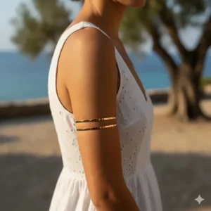 A model showcasing a layered look with two thin rose gold upper arm cuff bracelets stacked together.