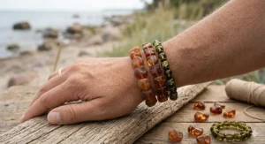 A photorealistic close-up of an adult male wrist wearing a stack of distinct Baltic amber bracelets, featuring cherry amber nuggets and cognac cubes.