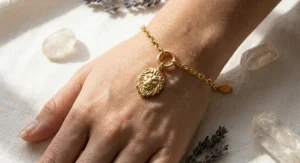 A bold Leo zodiac sign charm bracelet featuring a lion head pendant and gold link chain worn on a wrist.