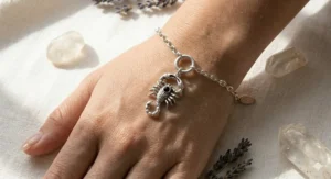 Sterling silver Scorpio zodiac charm bracelet highlighting the detailed scorpion motif and a dark obsidian bead.