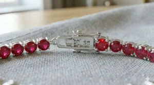 Detailed view of round-cut vibrant red rubies set in a sterling silver tennis bracelet chain.