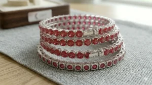 A side perspective of multiple ruby tennis bracelets showing the depth of the sterling silver basket settings.