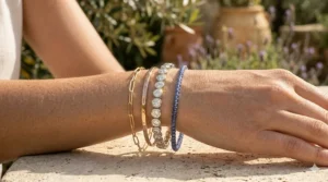 A stack of multiple bezel set diamond tennis bracelets of varying sizes on a wrist.