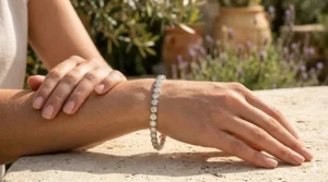 A woman wearing a bezel set diamond tennis bracelet paired with a luxury watch for a stacked look.