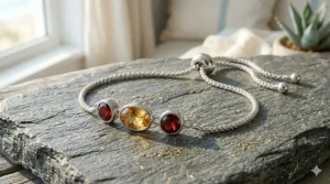Three stacked gemstone bolo bracelets in polished sterling silver on a model's wrist, creating a layered bohemian jewelry style.