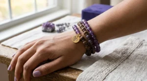 A woman wearing stacked silver and gold amethyst birthstone bracelets, showcasing a stylish February jewelry look.