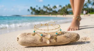 Adjustable gold anklet for women displayed against a coastal beach landscape.
