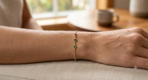 Dainty yellow gold family birthstone bracelet for mom featuring three small round cut stones symbolizing her children.