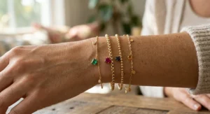 Layered gold family birthstone bracelet stack for mom showing a mix of chain styles and vibrant birthstone drops.