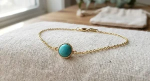Minimalist gold filled chain bracelet with a single round December birthstone turquoise charm.