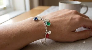 Personalized sterling silver mom bracelet adorned with teardrop shaped kids birthstones and tiny engraved initials.