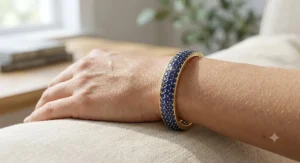 An elegant gold bangle bracelet adorned with rows of deep blue September birthstone sapphires.
