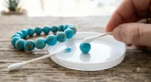 Dyed blue howlite bracelet shown next to acetone cotton swab test revealing color transfer