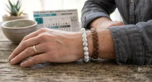 Man wearing a minimalist white howlite beaded stretch bracelet alongside a leather wristband