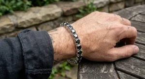 Men's heavy sterling silver tennis bracelet with black diamond accents worn on a male wrist.