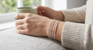 Layered stack of thin tarnish-resistant silver bracelets worn on a wrist for daily wear