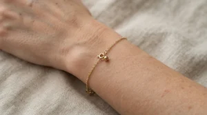 A delicate button-pearl bracelet for everyday wear paired with a casual linen button-down shirt.