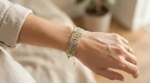 A delicate freshwater pearl bracelet worn on a woman's wrist against a soft neutral background.