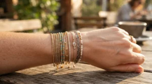 A gold chain layered with a freshwater pearl bracelet for a trendy stacked look.
