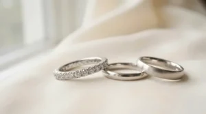 A luxury Swarovski crystal bracelet for weddings displayed on a satin pillow with wedding rings.